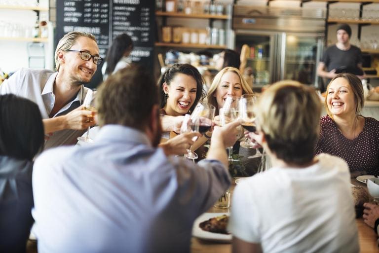 A group of people sitting at a table with wine glasses.